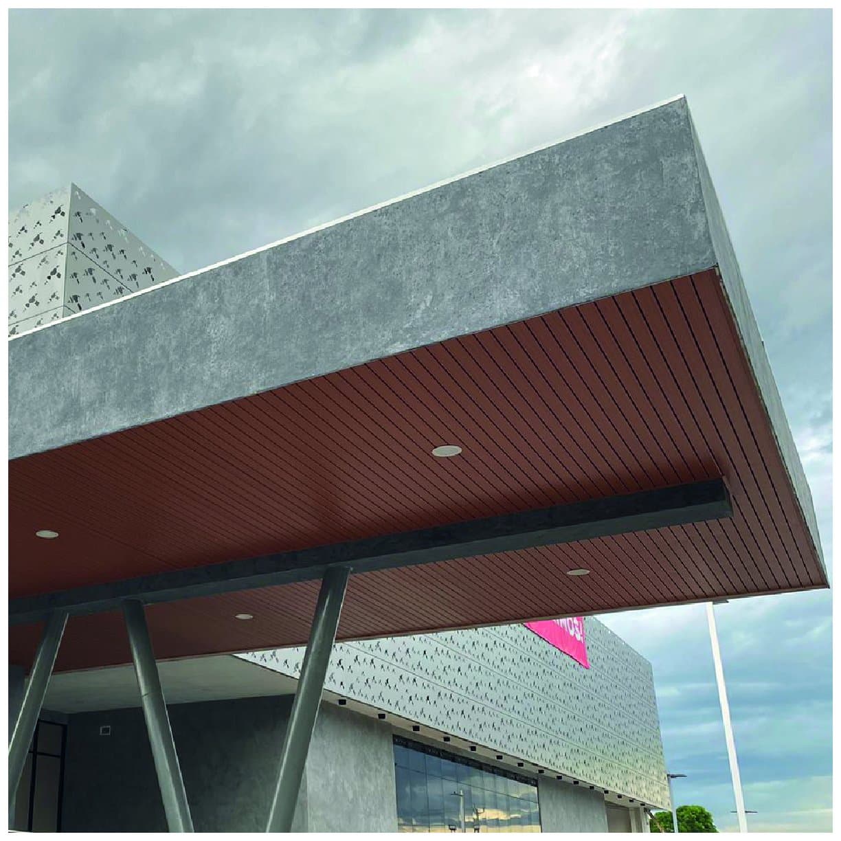 Canopy of a commercial building with an 84R linear metal ceiling in a wood finish