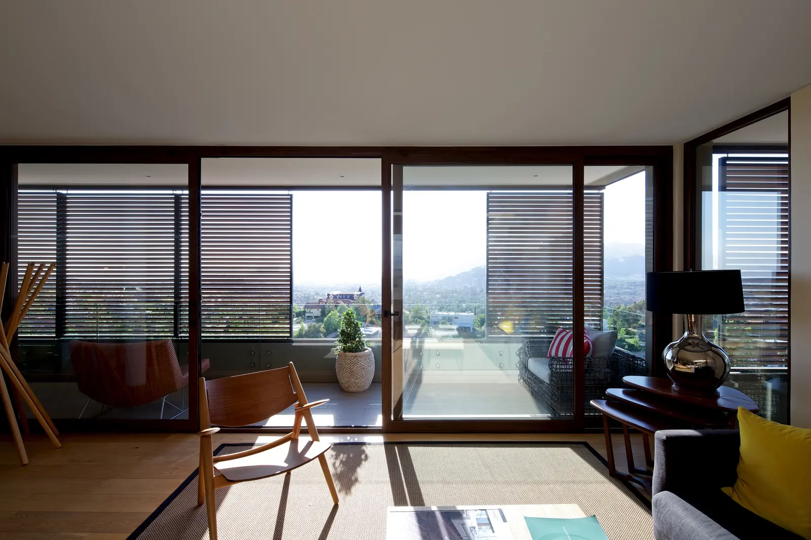 Apartment living room seen from inside, with slatted Metalbrise panels in front of the glazing