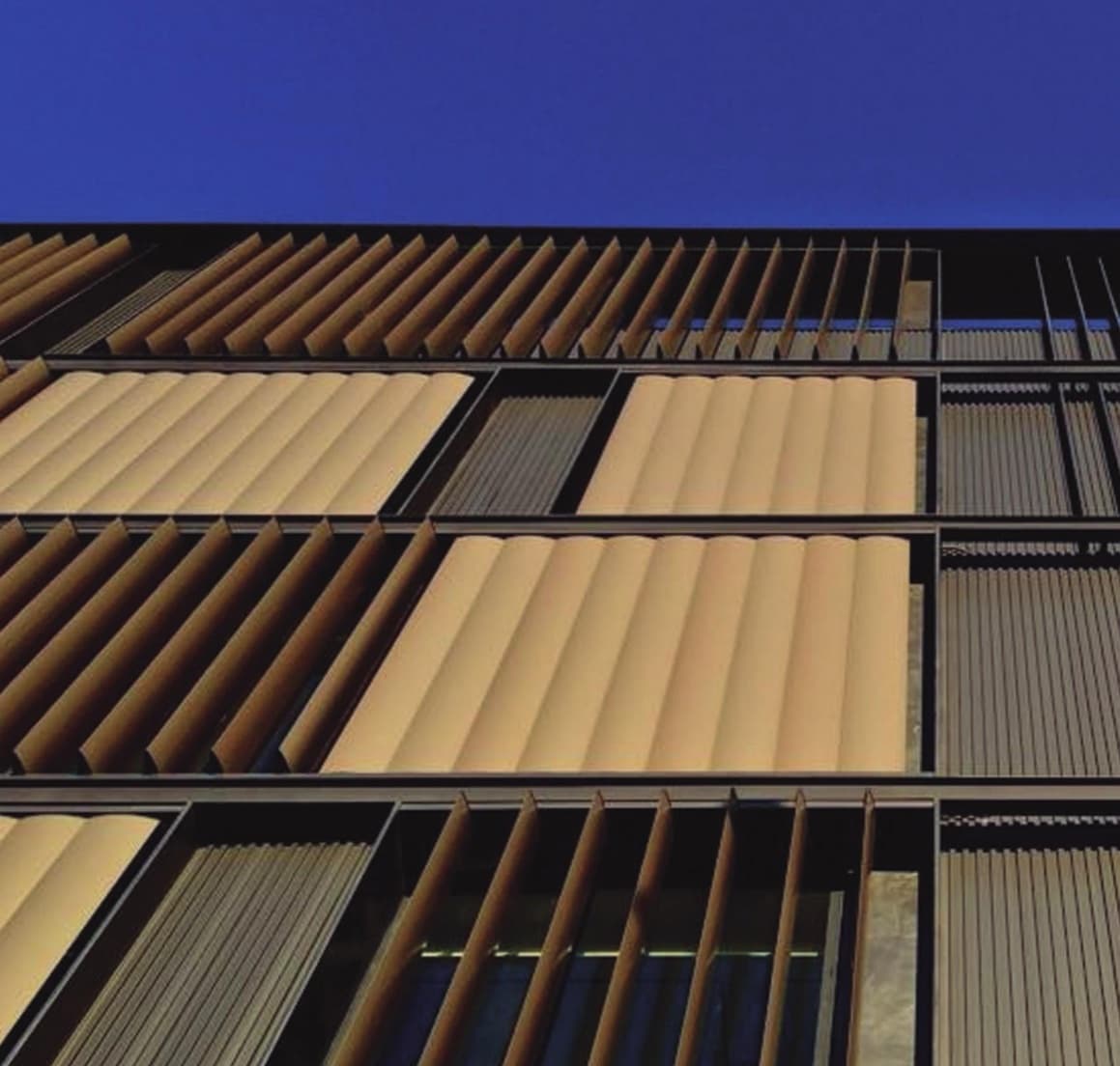 Façade with wood-tone TermoBrise blades, some turned and some closed